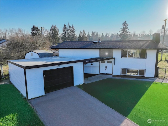 view of front of property featuring a garage and a front yard