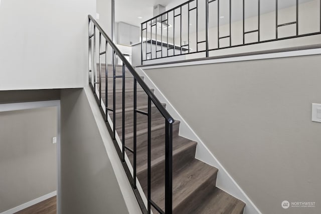 stairway featuring a towering ceiling and hardwood / wood-style floors