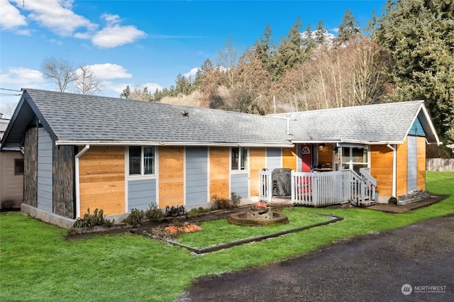 single story home with a shingled roof and a front yard