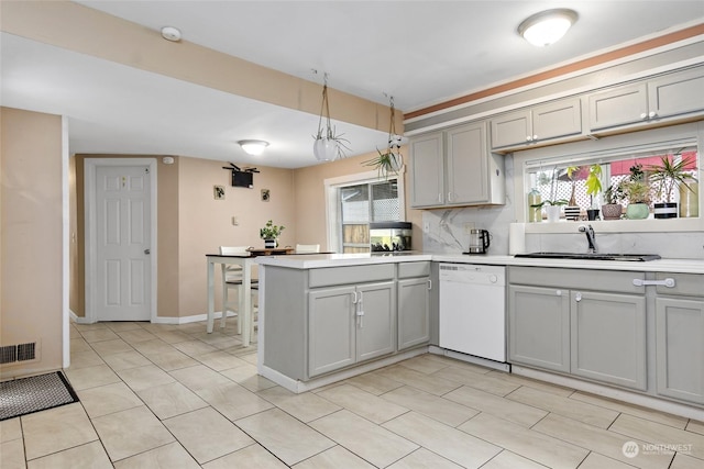 kitchen featuring light countertops, dishwasher, visible vents, and a sink