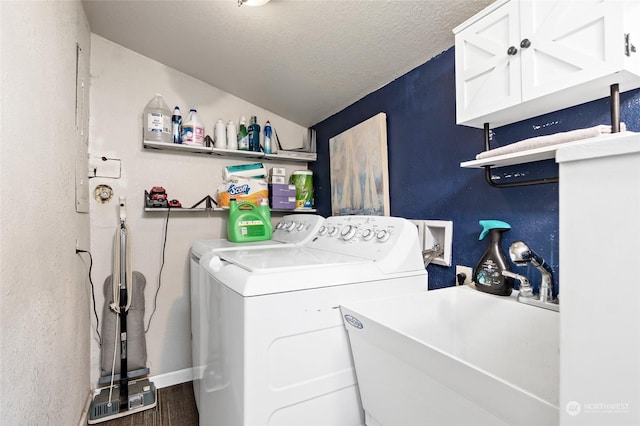 washroom with laundry area, washer and clothes dryer, wood finished floors, a textured ceiling, and a sink