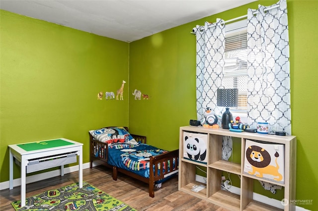 bedroom featuring wood finished floors and baseboards