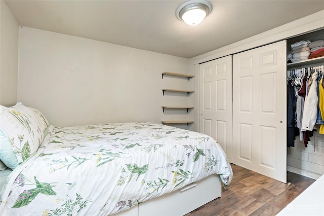 bedroom with a closet and dark wood finished floors