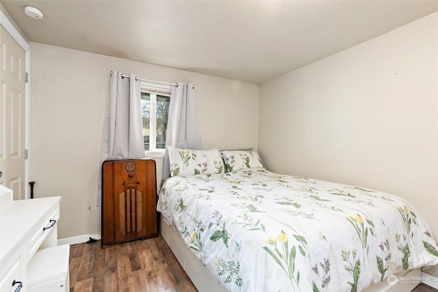 bedroom featuring dark wood-style flooring and baseboards