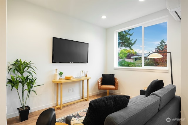 living room with hardwood / wood-style flooring, a wall mounted air conditioner, and plenty of natural light