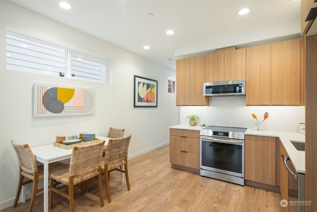 kitchen featuring decorative backsplash, light hardwood / wood-style flooring, and stainless steel appliances