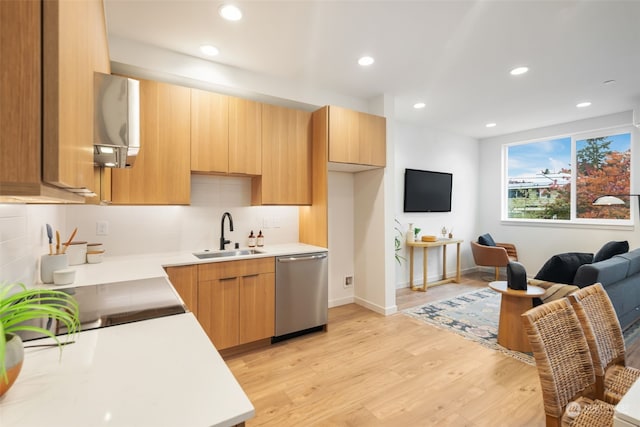 kitchen with tasteful backsplash, dishwasher, sink, light brown cabinets, and light wood-type flooring