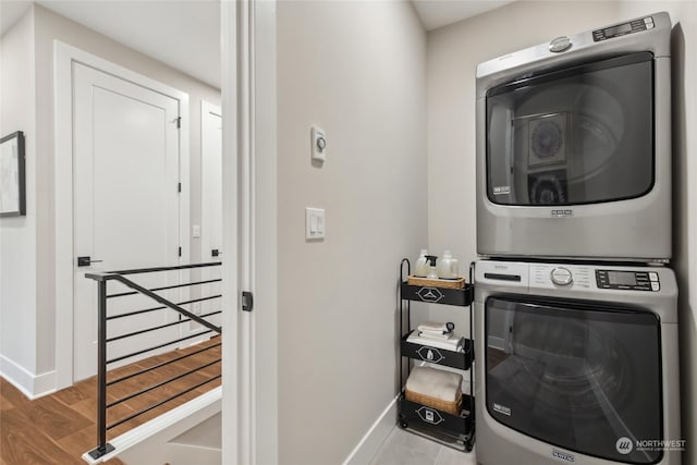 laundry area featuring stacked washer / drying machine and hardwood / wood-style floors