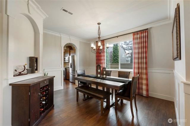 dining area with crown molding, dark hardwood / wood-style flooring, and a notable chandelier