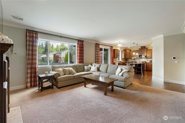 living room with crown molding and light colored carpet