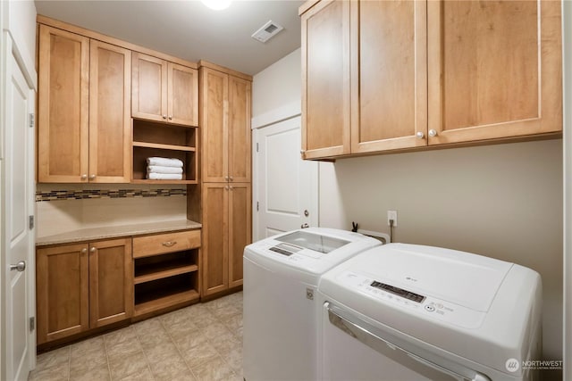 washroom with cabinets and washer and clothes dryer