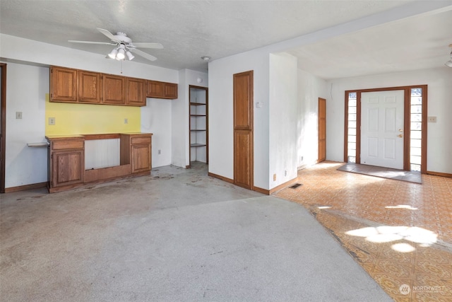 kitchen with light colored carpet, a textured ceiling, and ceiling fan