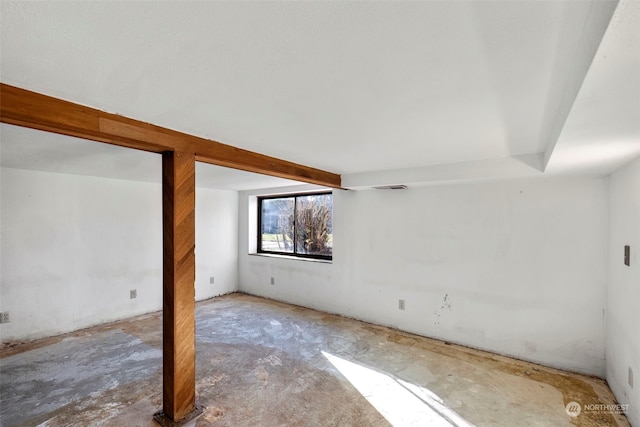 unfurnished room with beamed ceiling