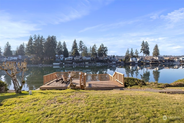 view of dock with a deck with water view and a lawn