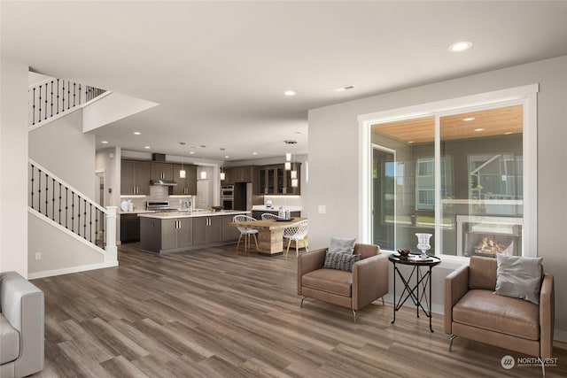 living area with stairway, dark wood-type flooring, and recessed lighting