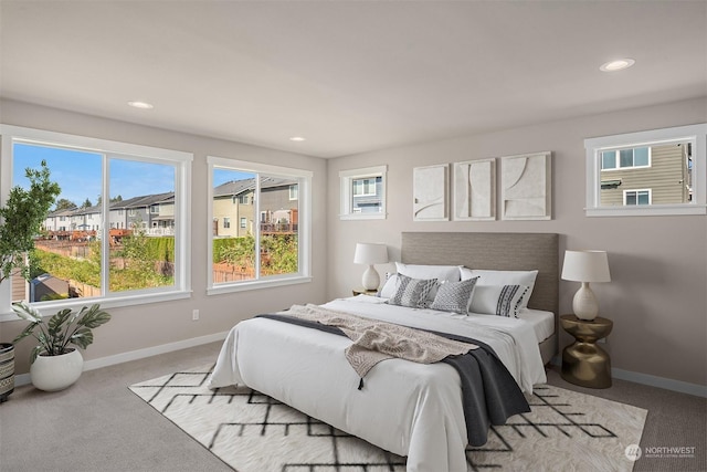 bedroom with light carpet, recessed lighting, and baseboards