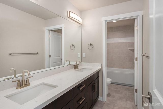 full bathroom with a sink, toilet, and double vanity