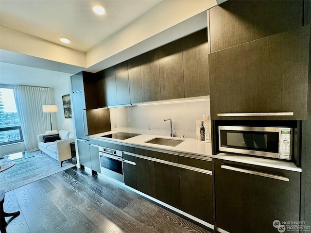 kitchen with appliances with stainless steel finishes, dark hardwood / wood-style floors, and sink