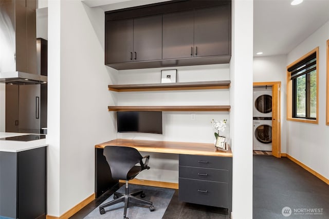 office space featuring stacked washer and dryer, recessed lighting, baseboards, and built in study area