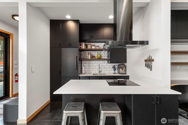 kitchen with island range hood, decorative backsplash, a breakfast bar, black electric stovetop, and open shelves