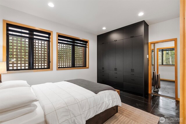 bedroom with dark tile patterned flooring and recessed lighting