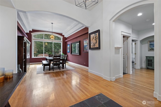 dining area featuring vaulted ceiling, a chandelier, and light hardwood / wood-style floors