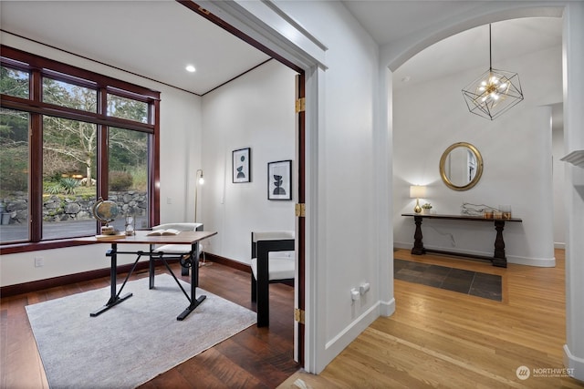 home office with wood-type flooring and a chandelier