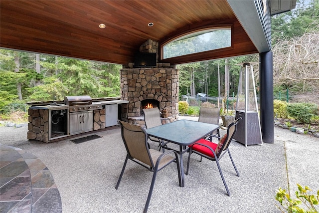 view of patio / terrace with an outdoor kitchen, grilling area, and an outdoor stone fireplace