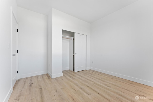 unfurnished bedroom with light hardwood / wood-style flooring and a closet