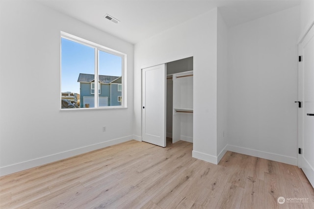 unfurnished bedroom featuring a closet and light wood-type flooring