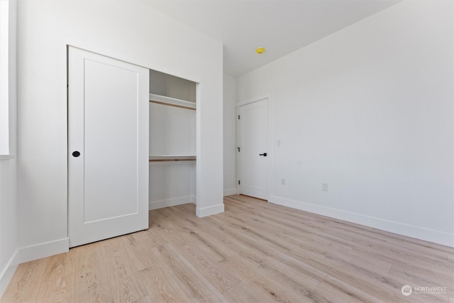 unfurnished bedroom with light hardwood / wood-style floors and a closet