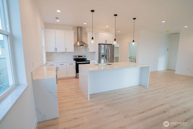 1300 Marina Dr Unit 12, Moses Lake, WA 98837 - kitchen with light wood-type flooring, appliances with stainless steel finishes, white cabinets, wall chimney exhaust hood, and a sink