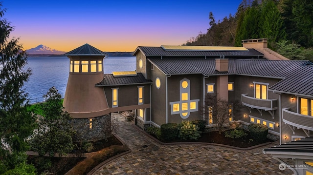 back house at dusk featuring a water view