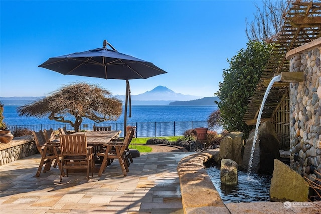 view of patio with a water and mountain view