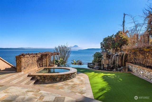 view of patio with a water and mountain view and an in ground hot tub