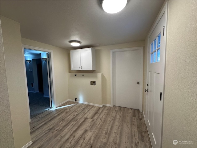 washroom with cabinets, light hardwood / wood-style flooring, and electric dryer hookup