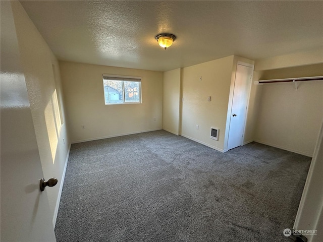 unfurnished bedroom with a closet, a textured ceiling, and carpet flooring