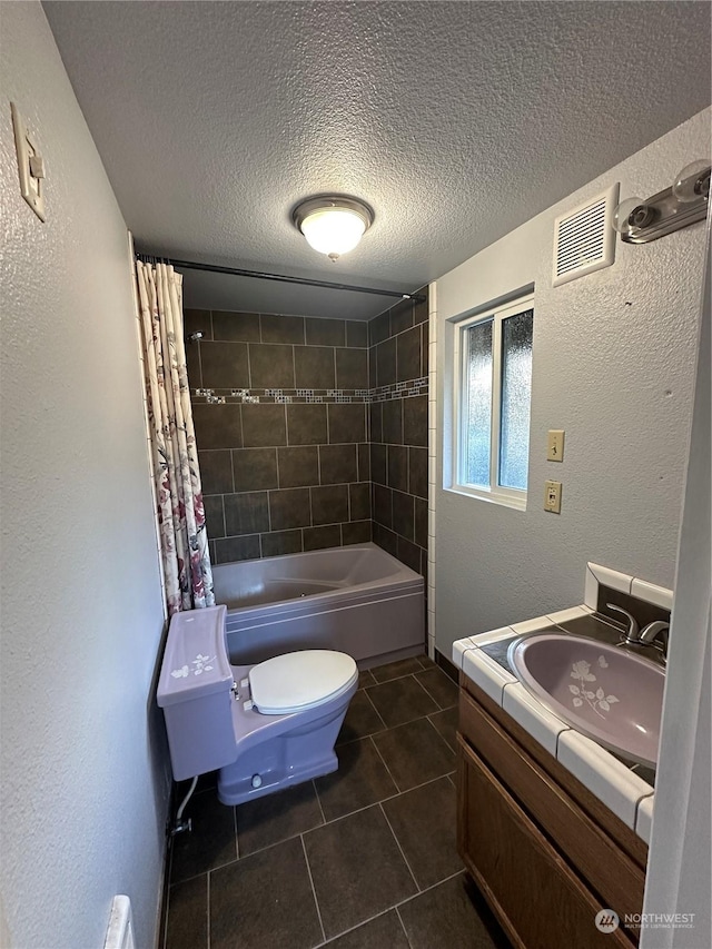 full bathroom featuring tile patterned floors, toilet, shower / tub combo, a textured ceiling, and vanity