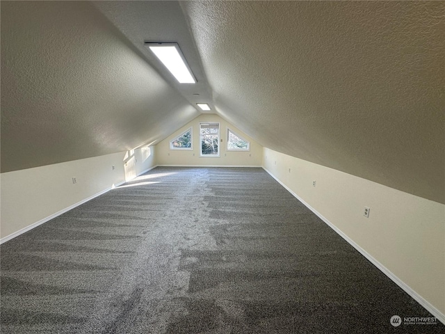 bonus room featuring carpet floors, vaulted ceiling, and a textured ceiling