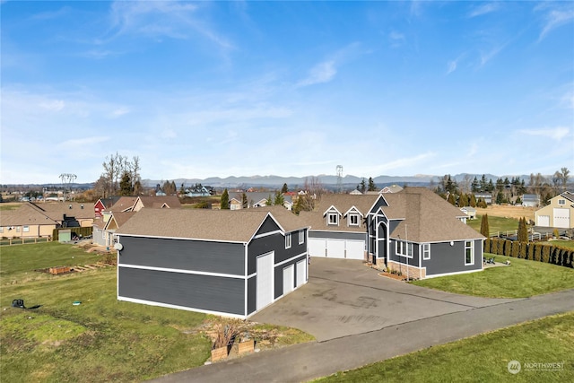 ranch-style house with a mountain view, a garage, and a front lawn