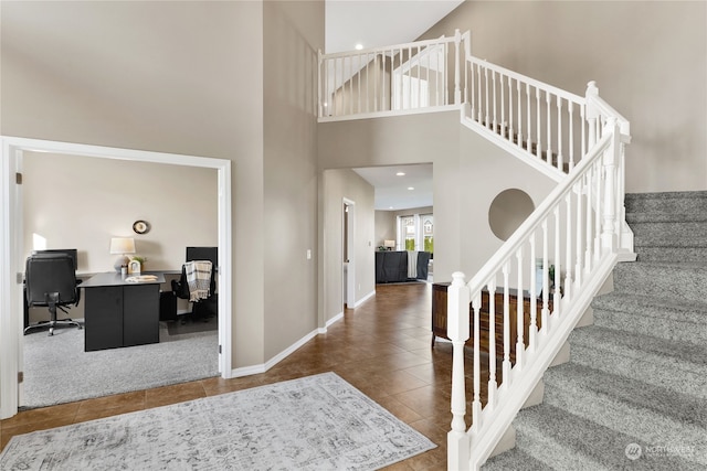 entryway with tile patterned flooring and a towering ceiling