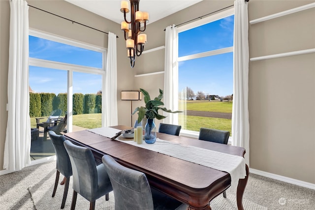 dining room with carpet flooring and a chandelier