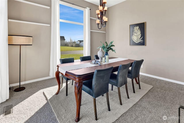 carpeted dining area with a notable chandelier