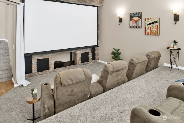 cinema room with a fireplace and carpet