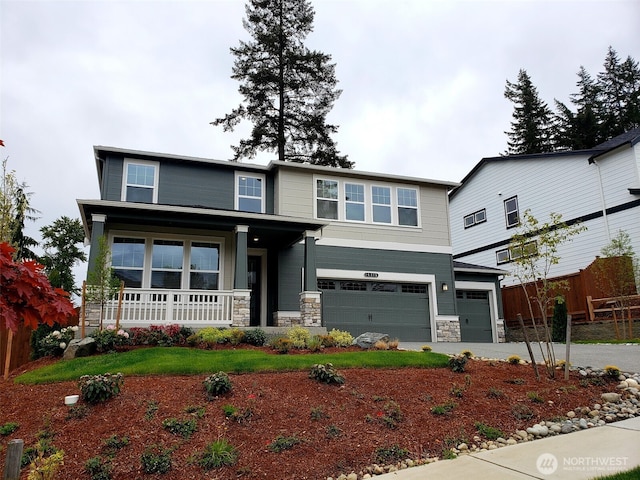 view of front of home featuring covered porch, driveway, a garage, fence, and stone siding