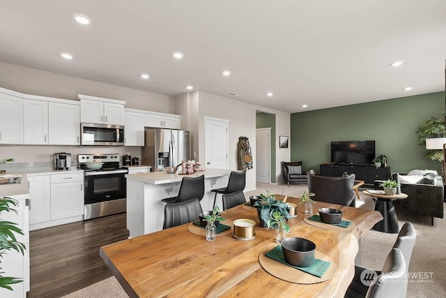 dining area featuring sink and dark wood-type flooring