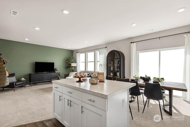 kitchen with white cabinetry, a kitchen breakfast bar, and a center island