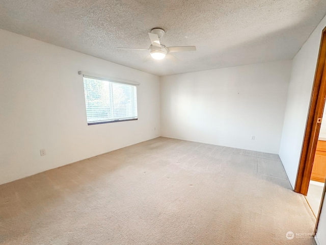 spare room with light carpet, a textured ceiling, and ceiling fan