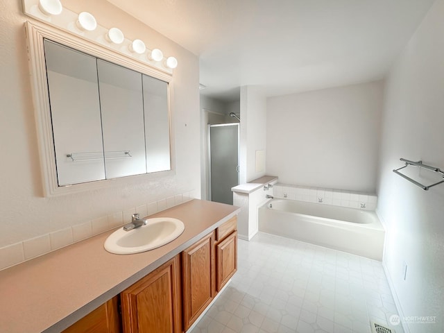 bathroom featuring vanity and separate shower and tub