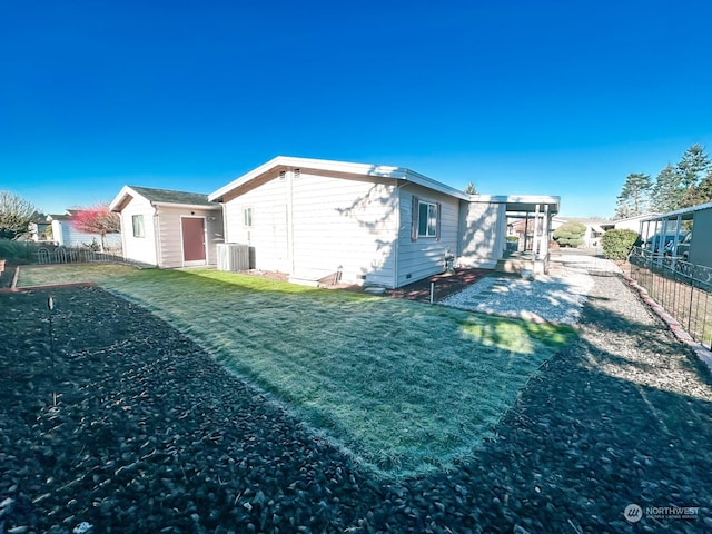 back of property featuring a yard and central AC